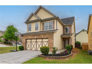 Charming two-story home with tan siding, stone accents, and a well-manicured front yard at 3637 Sweet Ashley Ln, Loganville, GA 30052