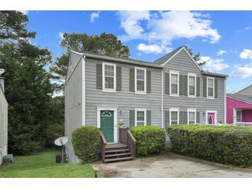 Charming home featuring a well-maintained exterior with a green door and a manicured front yard at 6420 Marbut Rd, Lithonia, GA 30058