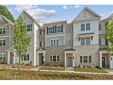 Charming townhomes with brick and siding facade, complemented by a well-maintained front lawn at 1991 Deco Dr, Kennesaw, GA 30144