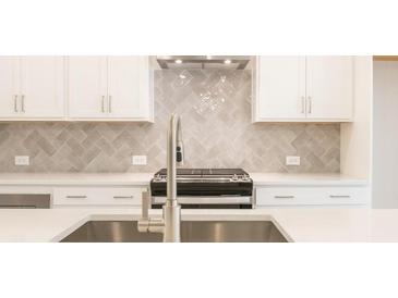 Modern kitchen features white cabinets, white countertops, stainless steel appliances, and tile backsplash at 1979 Deco Dr, Kennesaw, GA 30144