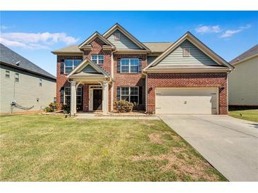 Charming two-story brick home with a well-manicured lawn and two-car garage at 385 Hinton Chase Pkwy, Covington, GA 30016
