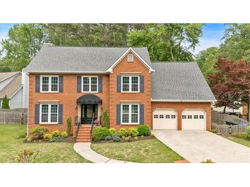 Charming two-story brick home with well-manicured lawn and attached two-car garage, offering classic curb appeal at 4067 Silver Fir Ct, Marietta, GA 30066