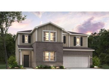 Charming two-story home with brick and siding, a two-car garage, and a well-manicured lawn at 7139 Brushwood Bend - Lot 42, Lithonia, GA 30058