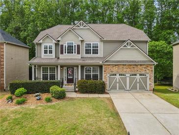 Charming two-story home featuring a stone-accented garage and well-manicured front yard at 4545 Evandale Way, Cumming, GA 30040