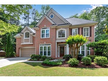 Charming two-story brick home with well-manicured lawn, lovely landscaping, and attached two car garage at 486 Milledge Gate Se Ter, Marietta, GA 30067