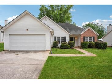 Charming single-story home with a well-manicured lawn, brick accents, and an attached two-car garage at 5525 Mayfair Crossing Dr, Lithonia, GA 30038
