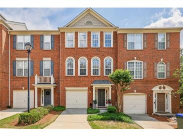 Attractive brick townhome exterior featuring a three-story facade, symmetrical windows, and well-maintained landscaping at 4004 Edgecomb Dr, Roswell, GA 30075
