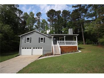 Charming home with gray siding, white trim, a front porch and an attached two-car garage at 443 Indian Hills Dr, Dallas, GA 30157