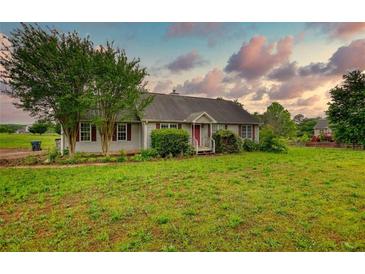 Charming ranch-style home with well-maintained lawn and mature trees, perfect for outdoor enjoyment at 2068 Hampton Locust Grove Rd, Locust Grove, GA 30248