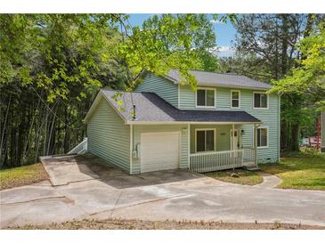 Charming two-story home with light green siding, covered porch, and a well-maintained front yard at 3688 Burnley Court, Lithonia, GA 30038