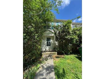 Modest two-story home with overgrown landscaping at 3739 Jamestown Ct, Doraville, GA 30340