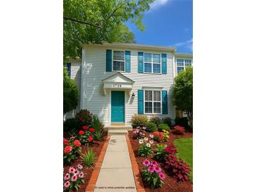 Charming townhouse featuring colorful flower beds, a blue door and shutters, and beautiful curb appeal at 3739 Jamestown Ct, Doraville, GA 30340
