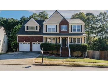 Charming two-story home with a brick facade, a two-car garage, and manicured landscaping at 981 Charles Hall Dr, Dacula, GA 30019