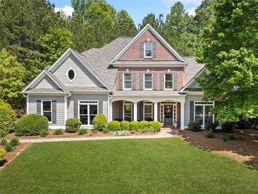 Charming two-story home boasts beautiful landscaping, a brick facade and a welcoming front porch at 295 River Laurel Way, Woodstock, GA 30188