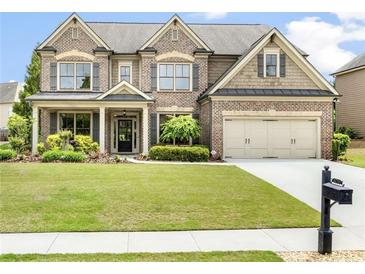 Charming two-story brick home with a well-manicured lawn and attached two-car garage at 4779 Moon Hollow Ct, Buford, GA 30519