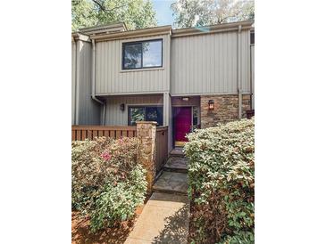 Charming townhome featuring a stone facade, a vibrant red door, and beautifully landscaped entryway at 1205 Druid Knoll Ne Dr, Brookhaven, GA 30319