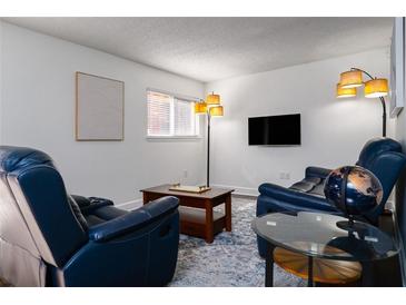 Cozy living room features comfortable blue leather seating, a sleek TV, and contemporary decor, perfect for relaxation at 381 Ralph Mcgill Ne Blvd # K, Atlanta, GA 30312