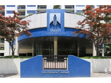 Building entrance with blue facade, manicured greenery, and prominent signage at 1130 Piedmont Ne Ave # 410, Atlanta, GA 30309