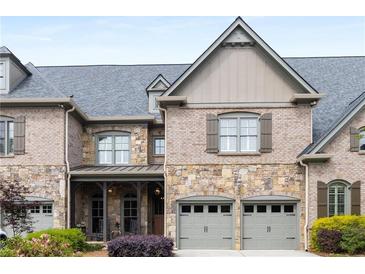 Charming townhome with stone and brick exterior, two-car garage and manicured landscaping at 320 Wisteria Cir, Roswell, GA 30076