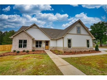 Charming two-story home with brick and siding, complemented by a well-manicured lawn and inviting walkway at 25 Oakbrook Ln, Covington, GA 30016