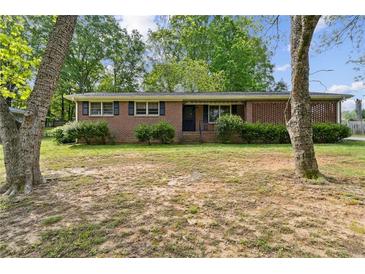 Charming brick home with green shutters and mature landscaping in a desirable neighborhood at 509 Woodland Ln, Lawrenceville, GA 30043