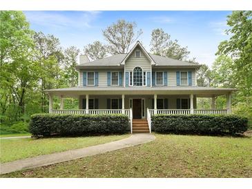 Charming two-story home with a welcoming front porch and lush landscaping at 569 Hale Mountain Ct, Hiram, GA 30141