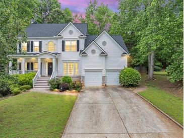 Charming two-story traditional home featuring a two-car garage, and a beautifully landscaped front yard at 115 Blue Ridge Trl, Powder Springs, GA 30127