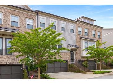 Beautiful multi-story brick townhome featuring an attached two-car garage and professionally landscaped front yard at 3592 Parkhaven Pl, Brookhaven, GA 30319