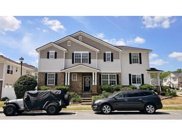 Charming two-story home with a stone facade, well-manicured lawn, and inviting curb appeal at 3811 Holliwell Pass, Cumming, GA 30040