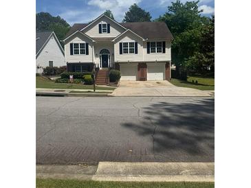 Charming two-story home featuring a two-car garage, landscaped yard, and inviting front entrance at 955 Tributary Way, Dacula, GA 30019