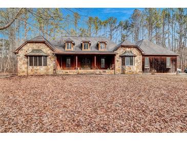 Stone home featuring a covered front porch and gabled roof in a private setting at 4220 Chapel Hill Farms Dr, Douglasville, GA 30135