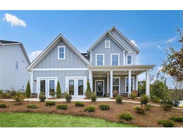 Charming two-story home with board and batten siding, inviting front porch, and professionally landscaped yard at 5230 Hyde Rd, Cumming, GA 30040