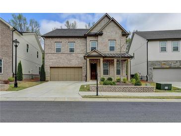 Charming two-story brick home featuring a well-manicured lawn, attached two-car garage, and welcoming front porch at 4391 Encore Blvd, Duluth, GA 30097