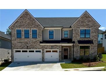 Charming two-story brick home with a two-car garage and beautifully landscaped front yard at 4055 Hosch Retreat Dr, Buford, GA 30519