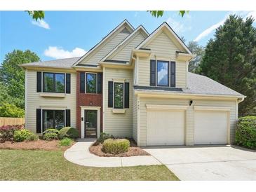 Charming two-story home with a two-car garage, complemented by lush greenery and a well-manicured lawn at 1745 Fairburn Dr, Cumming, GA 30040