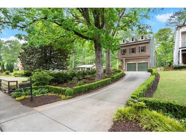 Charming brick home featuring a two-car garage and beautifully landscaped front yard with mature trees at 3668 Spring St, Chamblee, GA 30341