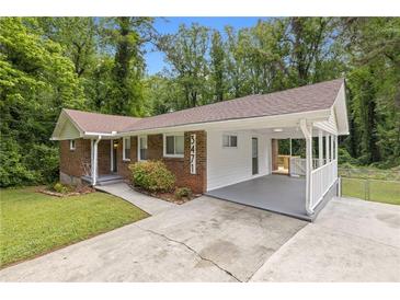 Charming brick home with a covered carport, landscaped yard, and newly painted white wood accents at 3471 Elgin Dr, Decatur, GA 30032