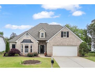 Charming single-story brick home featuring manicured landscaping, an attached two-car garage, and a welcoming front entrance at 5375 Glenhaven Dr, Cumming, GA 30041