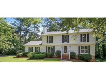 Traditional two-story home with a welcoming front porch and a well-maintained lawn with mature trees at 411 Woodstone West Dr, Marietta, GA 30068