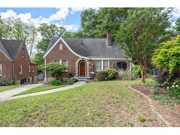 Charming brick home with a curved roofline, arched entryway, and lush landscaping at 1791 Melrose Sw Dr, Atlanta, GA 30310