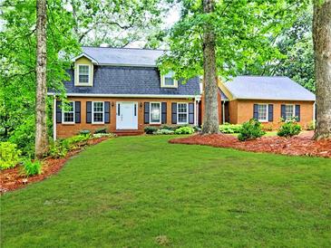 Inviting brick home featuring a lush green lawn and mature trees offering plenty of shade at 1257 Independence Way, Marietta, GA 30062