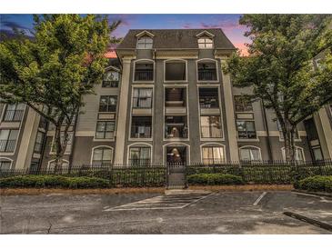 Beautiful condo building exterior with balconies, secure gate, and lush green landscaping at 2657 Lenox Ne Rd # C38, Atlanta, GA 30324