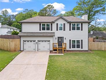 Charming two-story home featuring a spacious two car garage and a well-manicured lawn at 1923 Hamby Place Nw Dr, Acworth, GA 30102
