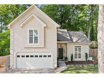 Charming home featuring an attached two-car garage and complemented by lush landscaping at 3376 Hickory Ln, Powder Springs, GA 30127