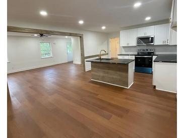 Modern kitchen with white cabinets, island, and stainless steel appliances at 472 Rigby Ne St, Marietta, GA 30060