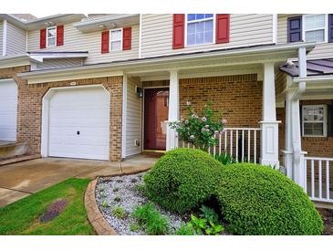 Charming townhouse featuring a brick facade, attached garage, and a beautifully landscaped front yard at 589 Fox Creek Xing, Woodstock, GA 30188