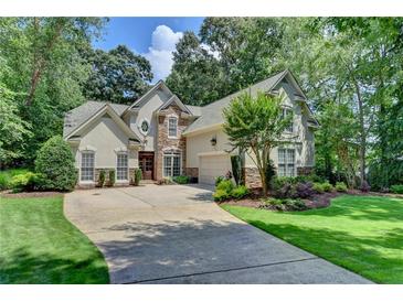 Charming two-story home with stone accents, mature trees, manicured landscaping, and a spacious driveway at 3265 Bentwood Close, Cumming, GA 30041