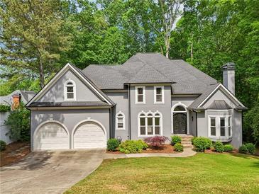Charming home with a well-manicured lawn, mature trees, and a two-car garage at 3851 Glenhurst Se Dr, Smyrna, GA 30080
