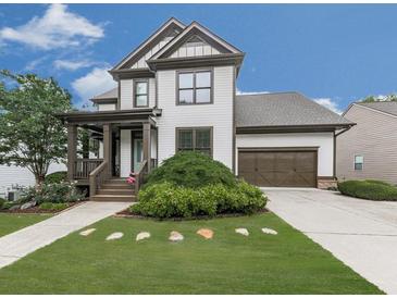 Charming two-story home featuring a welcoming front porch, well-manicured lawn, and an attached two-car garage at 215 Haleys Ct, Woodstock, GA 30188