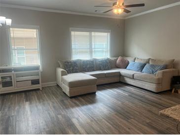 Bright living room with large sectional sofa and wood-look flooring at 243 Beau St, Lilburn, GA 30047